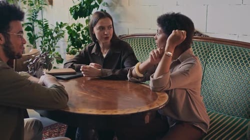 Three Diverse Friends Chatting in Restaurant