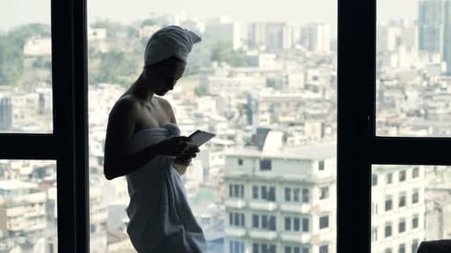 Relaxed Woman Texting by City Window