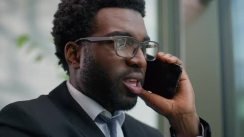 Bearded Man in Suit Talking on Cellphone in Office