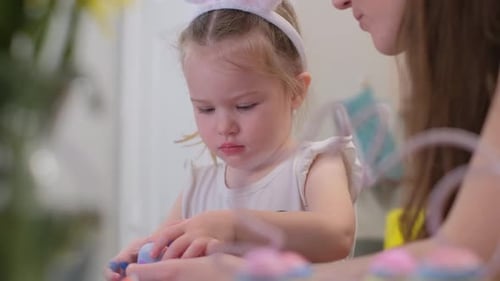Mother and Child Decorating Easter Eggs at Home