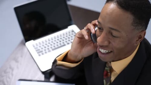 Man in Suit Talking on Phone at Desk
