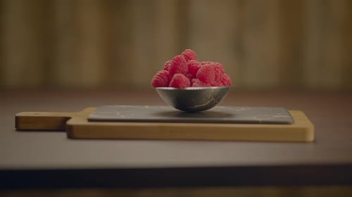 Bowl of fresh raspberries on a wooden table