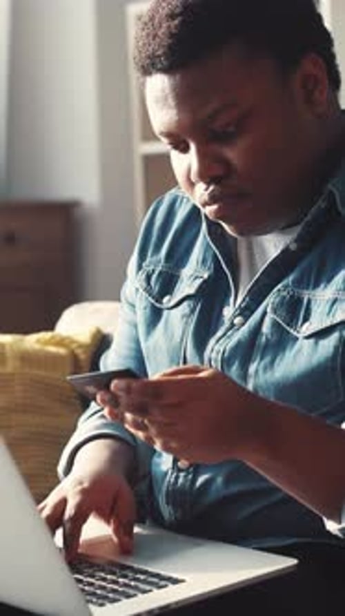 Ein fokussierter Mann macht Multitasking mit technischen Hinweisen beim Online-Shopping