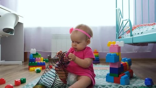 Infant Plays with Toys in Bright Room