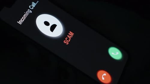 Smartphone Displaying Incoming Scam Call at Night