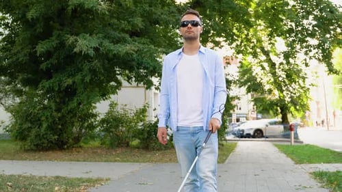 Ein blinder Mann geht auf die Straße, sehbehinderter Mann mit Gehstock