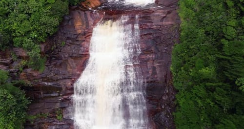 Aerial View of Majestic Waterfalls Cascading Through Dense Tropical Rainforest