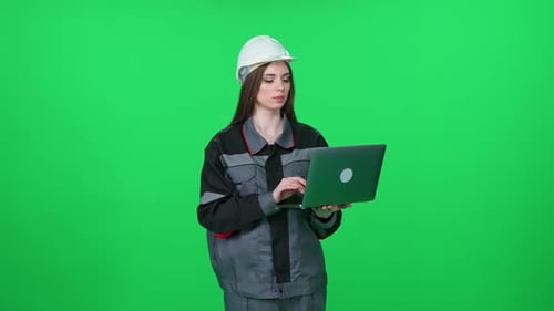 Portrait of a Focused Woman Worker in a Uniform and Protective Helmet Technical Engineer Stands and