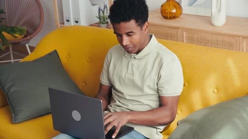 Man Using Laptop While Sitting on Couch