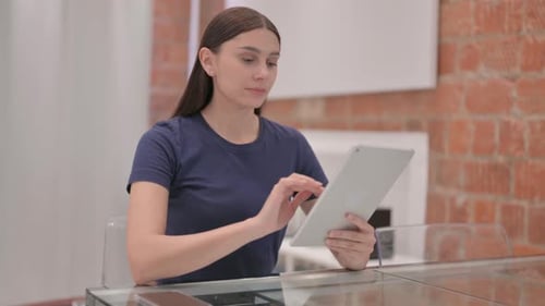 Woman Using Tablet Device at Glass Table