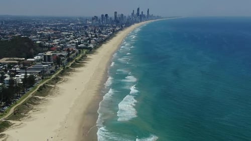 Statische Drohnenaufnahmen von Broadbeach und Surfers Paradise, Wellen, die an einem schönen Tag hereinrollen.