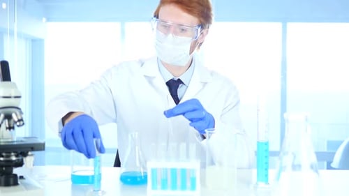 Scientist Working in Laboratory Pouring Chemical Solution in Test Tube