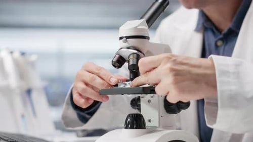 Scientist using microscope in lab for research