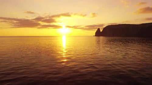 Aerial View on Sunset Over Calm Sea and Volcanic Rocky Shores
