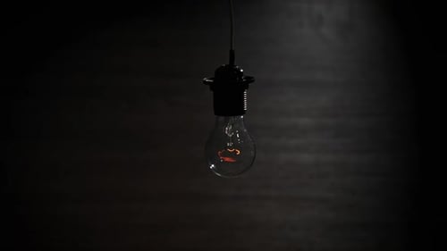 Vintage Lightbulb Flickering in Dark Room at Night