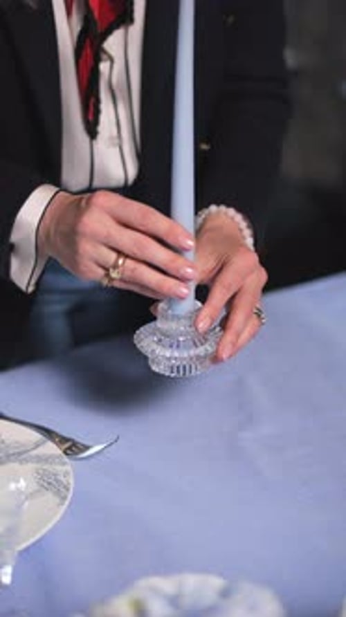 Hands Placing Candle on Blue Table Setting