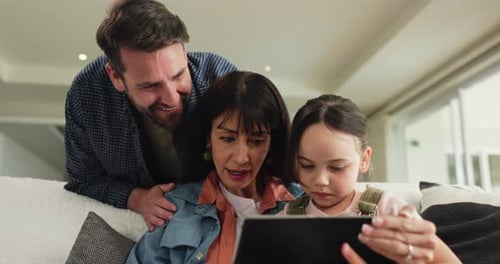 Parents, child and relax with tablet on sofa for playing games, educational research and bonding