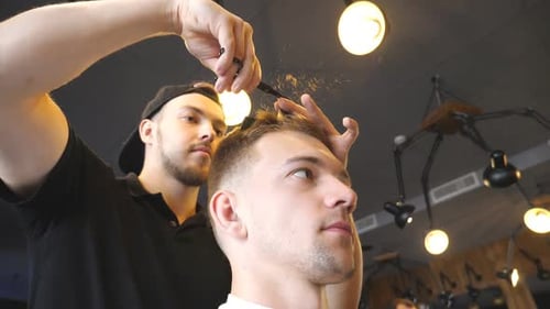 Man Getting Haircut by Barber in Urban Barbershop
