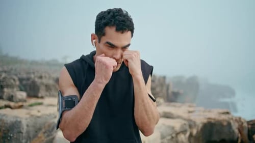 Man Practicing Boxing on Foggy Rocky Coast