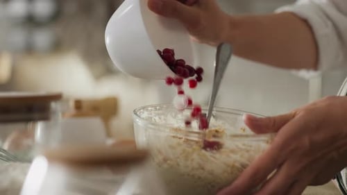 Baking sheet. Expectant mother in comfortable clothes preparing cookies with berries in the kitchen