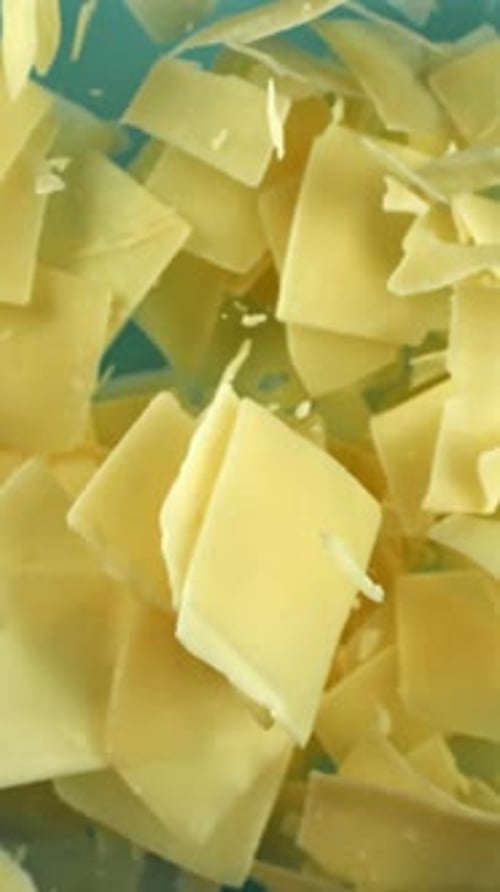 Parmesan Cheese Flies Up and Falls Down on a Blue Background Filmed on a Highspeed Camera at 1000