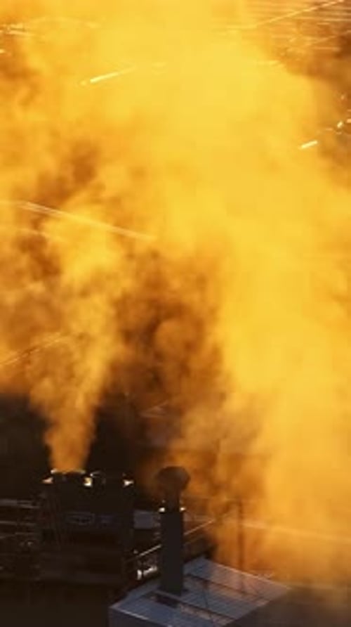 Industrial plant releasing smoke at golden hour