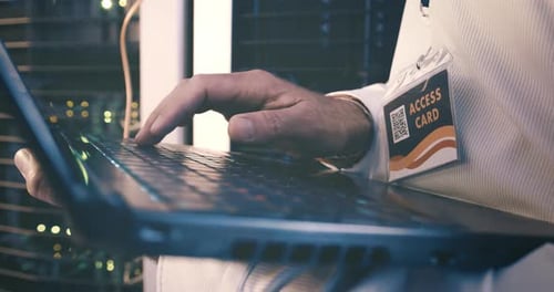 Mains d'une personne dans un centre de données avec un ordinateur portable, responsable de la maintenance du réseau ou ingénieur en stockage numérique