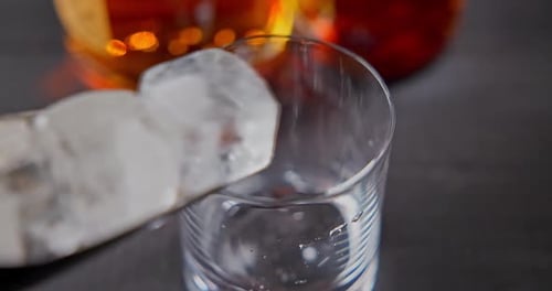 Ice Cubes Falling Into a Glass Close Up