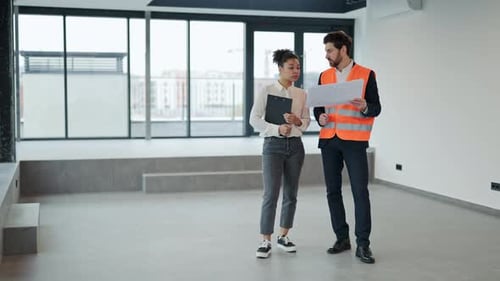 Investor and Architect Discuss Blueprint in Modern Office Space