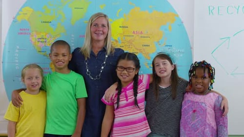 Teacher and multi cultural students smiling in elementary school classroom