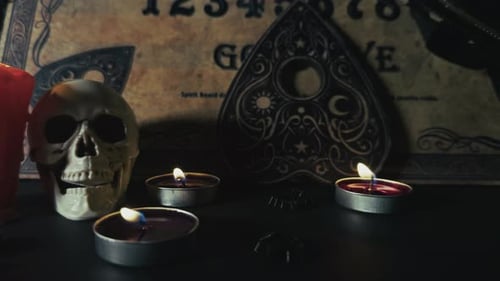 Spooky skull and candles on ouija board dolly