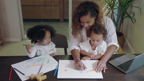 Woman Drawing with Two Young Girls Indoors