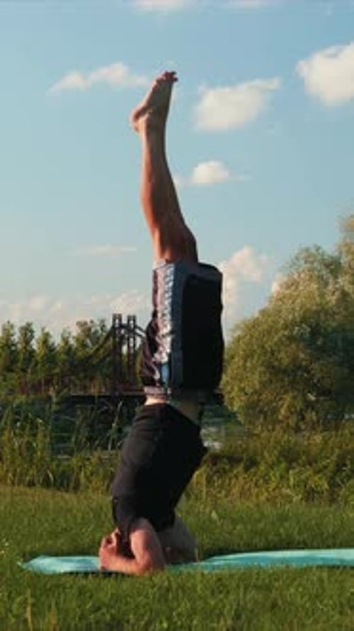 Man Practicing Yoga Headstand Outdoors on Yoga Mat