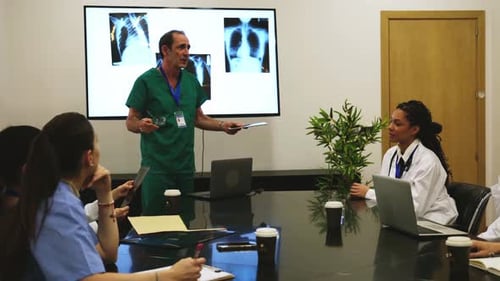 Medical Professionals Discussing Patient X-Rays in a Meeting