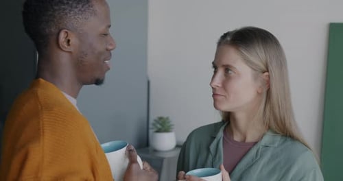 Couple drinking coffee and talking inside