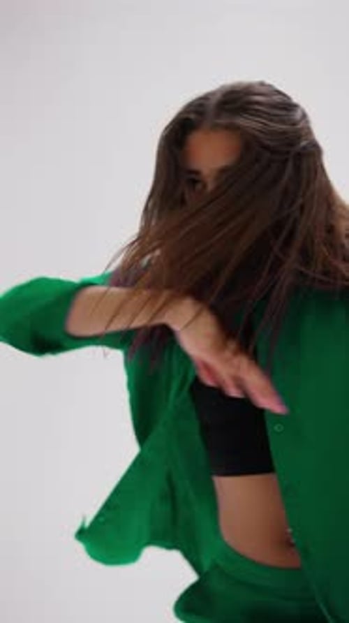 Young Woman Dancing In ColorChanging Outfit In White Studio