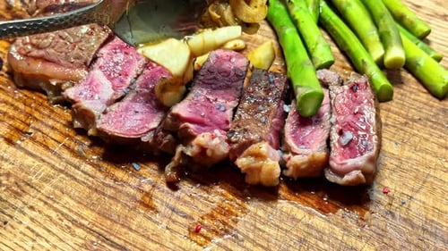 Medium Rare Steak Garnished with Asparagus and Garlic