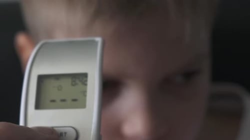 Dad Taking Sons Temperature Using a Digital Thermometer Covid 19 Virus Symptom - Epidemic