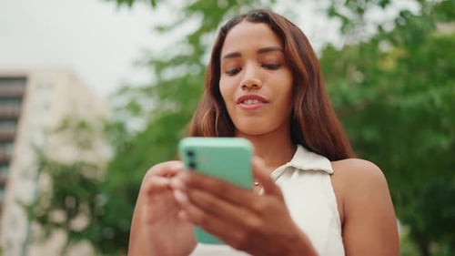 Woman Using Mobile Phone in Urban Park
