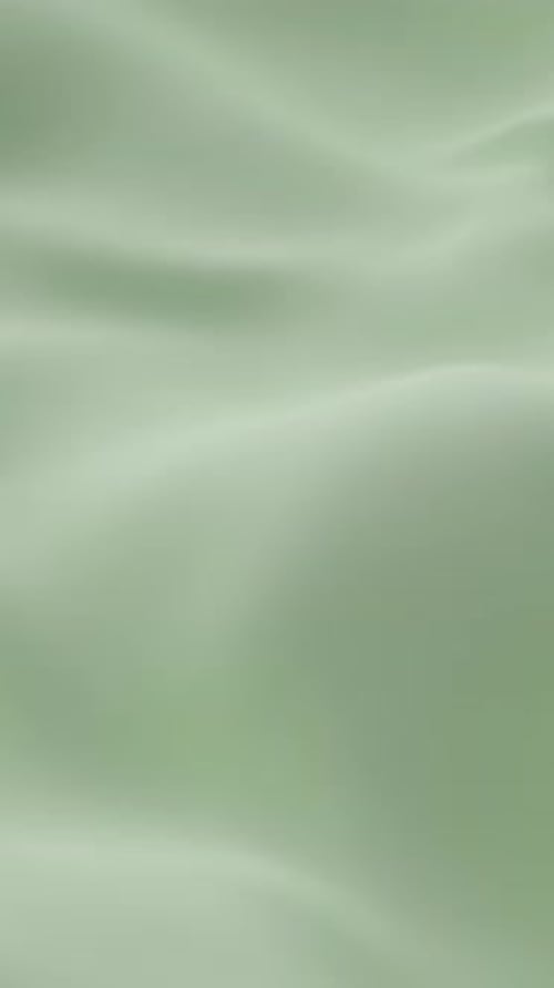 Soft Light Green Silk Fabric Gently Rippling Smooth Waves Creating Elegant Minimal Background