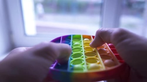 Closeup of Man Fingers Playing Pop It Having Fun with Popular Fidget Toy