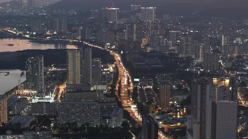 City at night with tall buildings and a river in the background