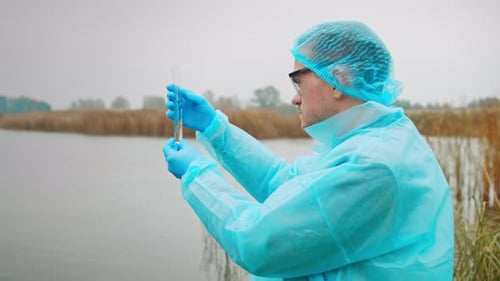 Biologist Looks At Flask With Water Taken From Pond For Visible Contamination Biologist And