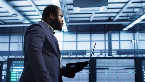 Man with Laptop in Modern Server Room