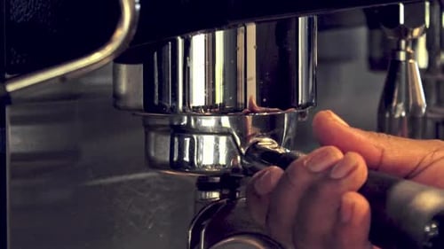 Putting the portafilter on an expresso in a café - isolated close up