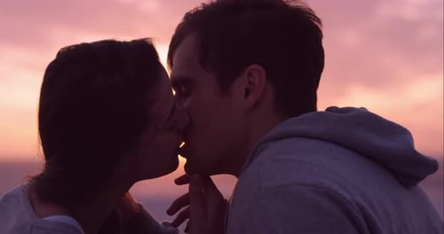 4k video footage of a couple kissing on the beach at sunset
