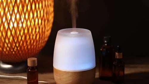 Aromathérapie. Lampe aromatique et huiles essentielles sur une table en bois à l'intérieur, gros plan