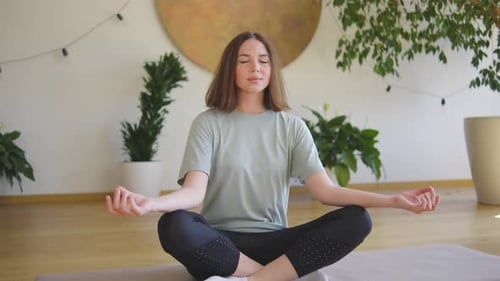 Woman Meditating in Lotus Position at Home