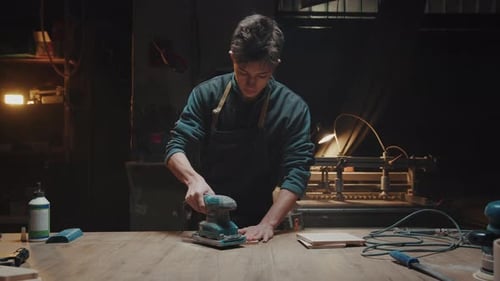Young Man Works in His Workshop Polishing Wooden Parts and Blanks Carpenter and His Small Family