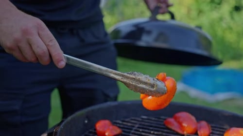 Gemüsegrill auf einem runden Grill auf einer Wiese Sommerpicknick mit gegrillten Paprika